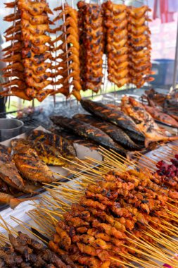 Kota Kinabalu 'daki Ramazan pazarında ızgara ve ızgara balık ve tavuk kanadı ve satay.