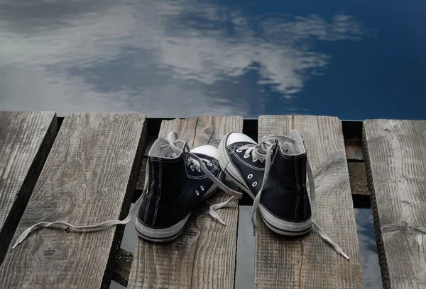 Kavramı köprü kenarında duran siyah çocuk ayakkabı