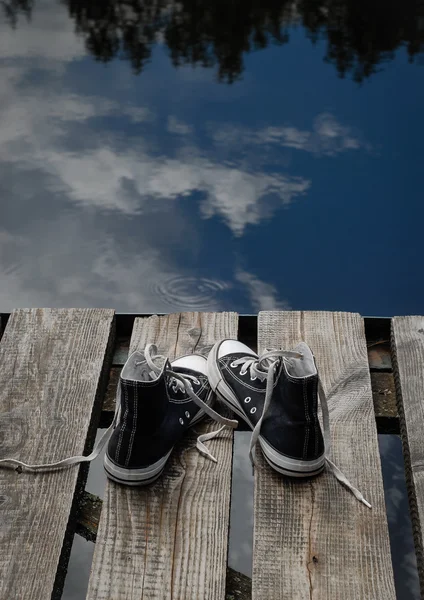 Kavramı köprü kenarında duran siyah çocuk ayakkabı