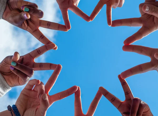 Schwarze und weiße Menschen formen mit ihren Fingern neun spitze Sterne. — Stockfoto