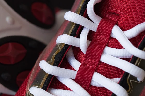 Крупный план красного кроссовка с белыми шнурками — стоковое фото