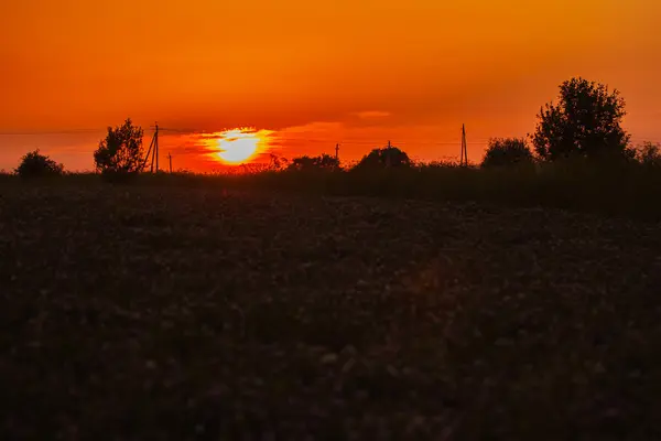 Pôr-do-sol vermelho em dia nublado na aldeia — Fotografia de Stock