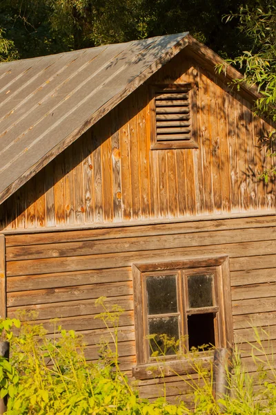 Старый заброшенный деревянный дом с разбитым окном — стоковое фото