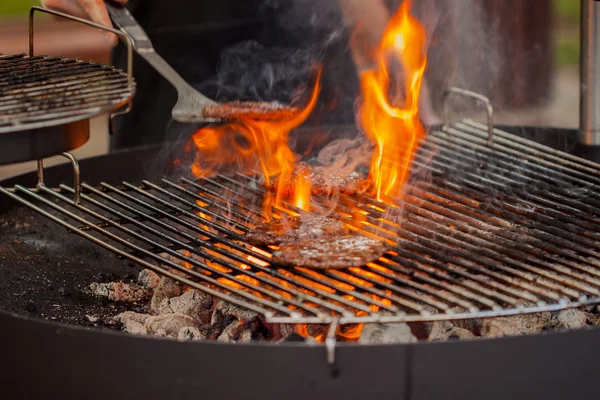 Grill, erős égő láng, a Burger pogácsákat — Stock Fotó