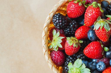 Ürün yelpazesine Karpuzu yaban mersini, çilek, ahududu ve böğürtlen ile hasır kase. Rustik tarzı. Üstten Görünüm.