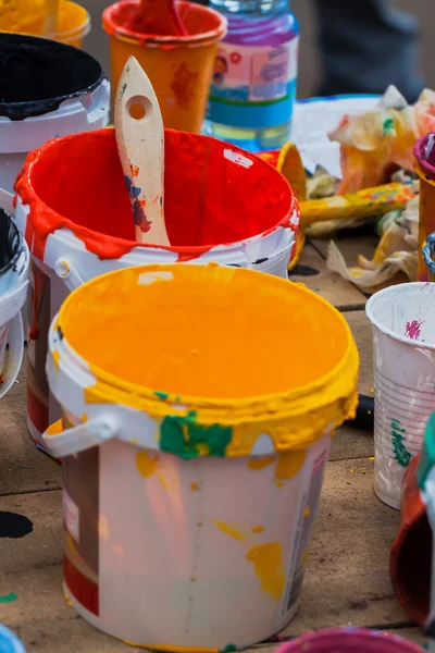 Multi-gekleurde verven in potten en penseel op de tafel, creatieve chaos — Stockfoto