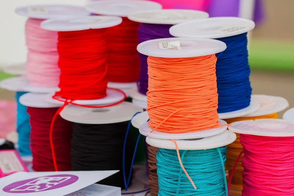 Varios colores de cuerdas brillantes en bobinas para tipos de creatividad, enfoque selectivo — Foto de Stock