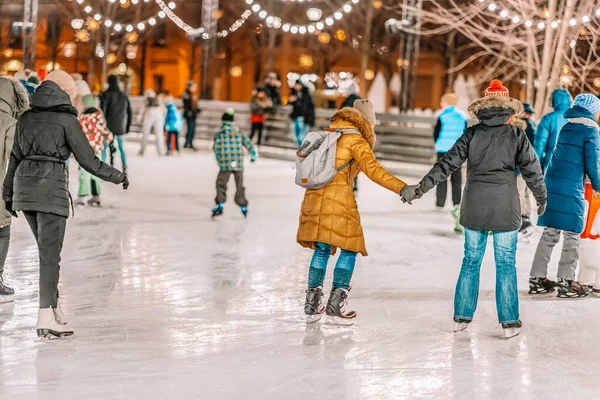 Happy couples, friends ice skate on a skating rink in a city park together. Healthy winter outdoor activities — Stock Photo, Image