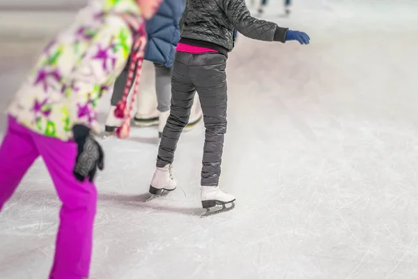 Group of children, girls are skating in the park on winter rink, motion blur, selective focus. Christmas, sport, healthy lifestyle. — Stock Photo, Image