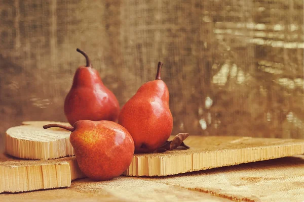 Fresh ripe organic red pears on wooden saw cut, vintage background, copy space. Healthy food and harvest concept — Stock Photo, Image