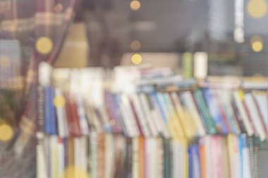 Vitrinin arkasında renkli kitapları olan bulanık kitapçı kitaplıkları. Kitap okumak ve satmak..