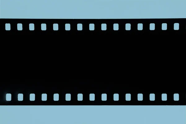Bande de vieux film celluloïd, Vieux film photographique, négatif sur fond bleu — Photo