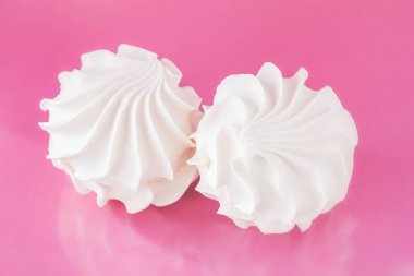 Hassas pembe bir arka planda narin, havadar marşmelov. Sağlıklı meyve tatlısı. Üst görünüm.