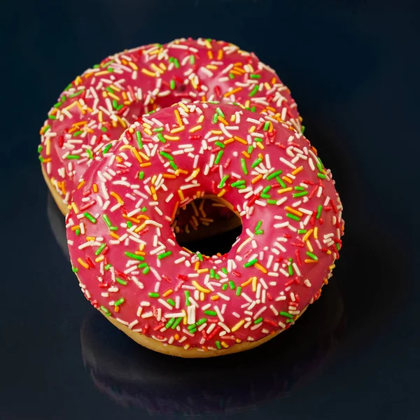 Zwei hell glasierte Donuts auf dunklem, minimalistischem Hintergrund, Draufsicht — Stockfoto