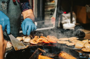 Metal barbekü ızgarasında karides ve diğer deniz ürünleri hazırlama işlemi. Yaz pikniği, arka bahçede barbekü