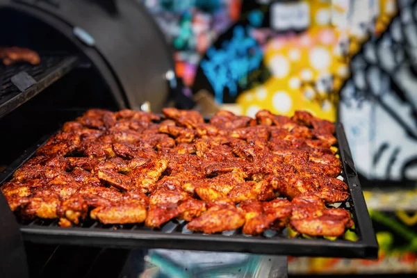 Appetizing crispy chicken wings in spicy marinade, grill close-up outdoors. Concept of summer picnic, backyard barbecue — Stock Photo, Image