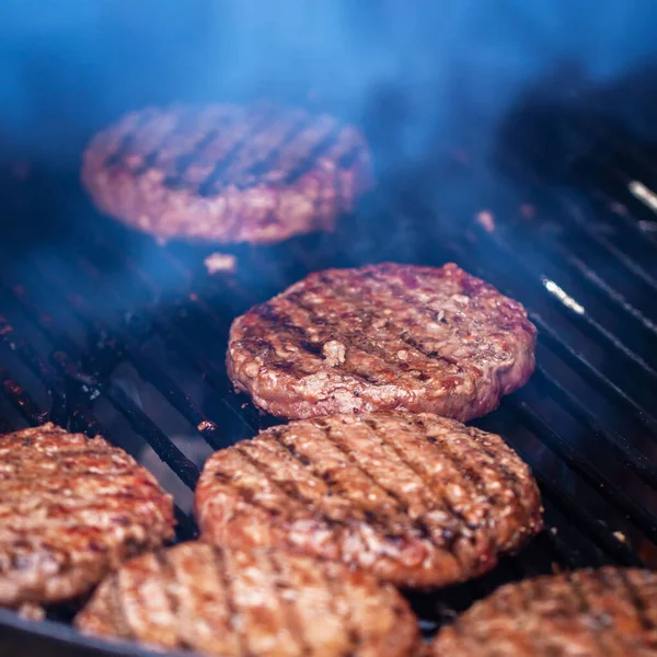 Process of preparing Hamburgers on an Outdoor Grill. BBQ grill with roasted Meat in smoke — Zdjęcie stockowe