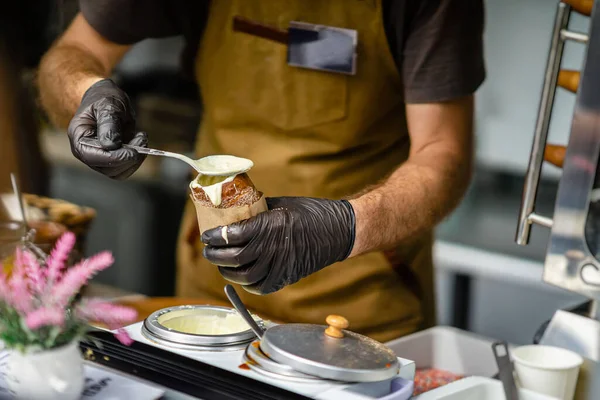 Male Hands of chef making Trdelnik. National street food, cake made out of sweet dough rolled around spit and grilled — Φωτογραφία Αρχείου