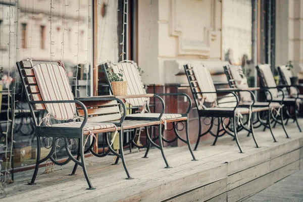 Row of empty Comfortable chairs on the street on sunny day on wooden platform. Vintage. Leisure furniture, recreation — Foto de Stock
