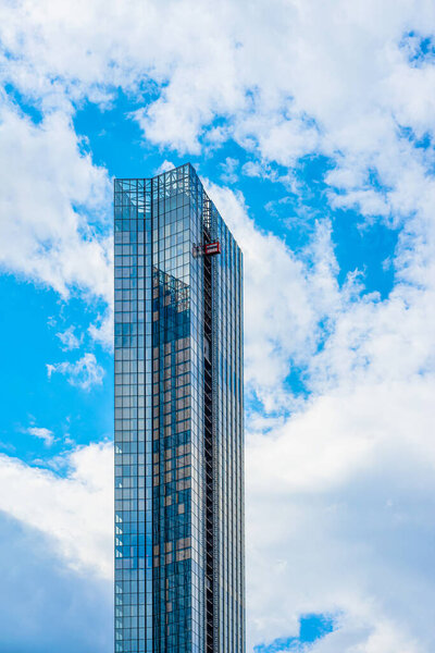 High modern Skyscraper under construction against blue sky. Housing, construction concept. Vertical background, copy space
