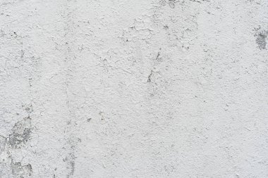 Açık gri eski duvar, yakın plan, alçı soyma. Yüzeyde çatlaklar var. Eski arkaplan