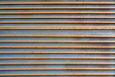 Rusty Metal Vent Texture. Horizontal rusty metal wall with weathered surface. Industrial design, aged steel texture, grunge background concept