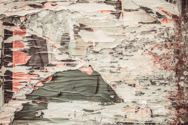 Duvardaki yırtık poster deseni, solmuş şehir posterleri. Soyut çürüme, klasik nostalji ve eski sokak sanatı estetiğinin arka planı