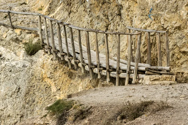 高山上陡峭悬崖附近的木桥 免版税图库图片