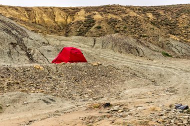 Tepedeki bozkırda yalnız kırmızı çadır. CORONAVIRUS (COVID-19) salgını sırasında ıssız bir yerde mükemmel bir kaçış.