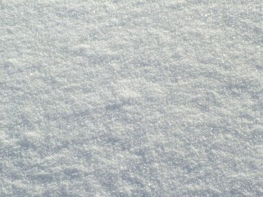 Güneşli bir sabahta karın yüzeyi sürüklenir.