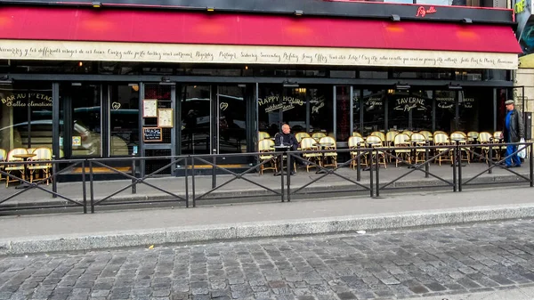 Paris, Fransa - 19 Mart 2014: Kafenin yalnız ziyaretçisi ve Clichy Bulvarı 'ndan geçen yalnız yolcu