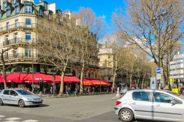 Paris, Fransa - 22 Mart 2014: Güneşli bir bahar gününde Saint-Germain Bulvarı. Baron Haussmann 'ın tipik mimarisi.