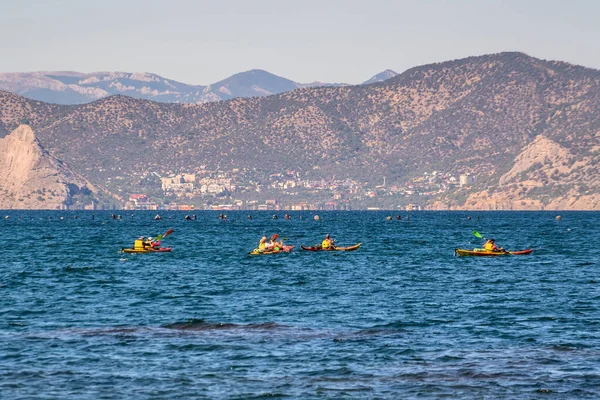 Sudak, Kırım - 9 Eylül 2020: Novy Svet köyü ve ormanlık dağlarda deniz kanoları üzerinde turistler