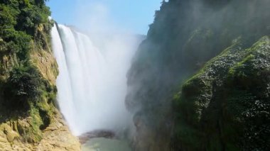 Cascada de Tamul tropikal bitkilerle çevrili yüksek bir uçurumdan düşen güçlü su gösteriyor. İnsanlar bu doğal alanın güzelliğini San Luis Potosi, Meksika 'da yaşıyorlar..