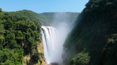 Cascada de Tamul tropikal bitkilerle çevrili yüksek bir uçurumdan düşen güçlü su gösteriyor. İnsanlar bu doğal alanın güzelliğini San Luis Potosi, Meksika 'da yaşıyorlar..