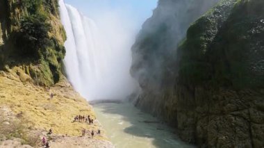 Cascada de Tamul tropikal bitkilerle çevrili yüksek bir uçurumdan düşen güçlü su gösteriyor. İnsanlar bu doğal alanın güzelliğini San Luis Potosi, Meksika 'da yaşıyorlar..