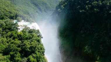 Cascada de Tamul tropikal bitkilerle çevrili yüksek bir uçurumdan düşen güçlü su gösteriyor. İnsanlar bu doğal alanın güzelliğini San Luis Potosi, Meksika 'da yaşıyorlar..