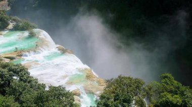 Cascada de Tamul tropikal bitkilerle çevrili yüksek bir uçurumdan düşen güçlü su gösteriyor. İnsanlar bu doğal alanın güzelliğini San Luis Potosi, Meksika 'da yaşıyorlar..
