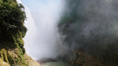 Cascada de Tamul tropikal bitkilerle çevrili yüksek bir uçurumdan düşen güçlü su gösteriyor. İnsanlar bu doğal alanın güzelliğini San Luis Potosi, Meksika 'da yaşıyorlar..