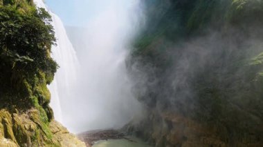 Cascada de Tamul tropikal bitkilerle çevrili yüksek bir uçurumdan düşen güçlü su gösteriyor. İnsanlar bu doğal alanın güzelliğini San Luis Potosi, Meksika 'da yaşıyorlar..