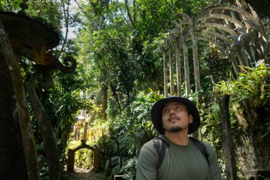 Turistler Castillo de Edward James 'in Xilitla' daki gerçeküstü tasarımına hayran. Bereketli tropikal bitkiler parlak güneş ışığı altında beton yapının etrafını sarar..
