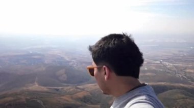 Silao, Guanajuato, Meksika 'da Cristo Rey' in tepesinde bir kişi duruyor. Güneşli bir günde aşağıdaki dağlara ve vadilere bakarlar. Manzara uzaklara kadar uzanıyor..