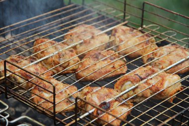 Pişirme Barbekü tavuk uyluk kömürlerin üzerinde.