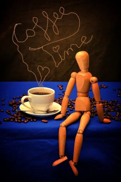 Coffee cup and coffee beans with wooden figure on wooden table  with a coffee Time lettering above cup