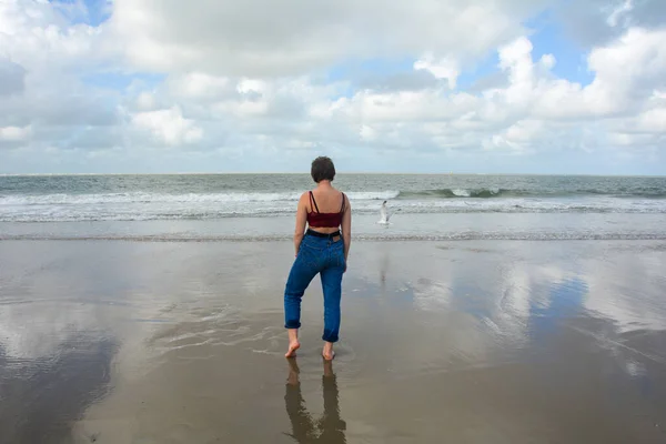 Young Girl Jeans Short Top Stands Barefoot Sandy Beach Front — Zdjęcie stockowe