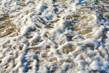 Kumsalda bir dalganın köpüğü