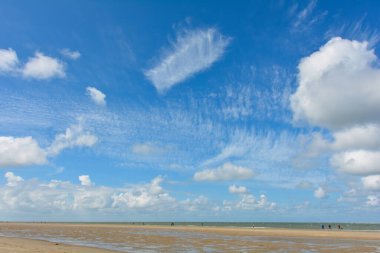 Arka plan olarak kumsaldaki mavi gökyüzünde bulutlar