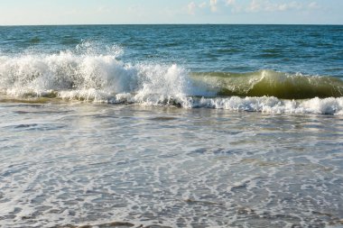 Mavi gökyüzü ile kumsalda dalgalar