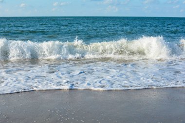 Mavi gökyüzü ile kumsalda dalgalar