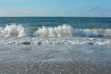 Mavi gökyüzü ile kumsalda dalgalar